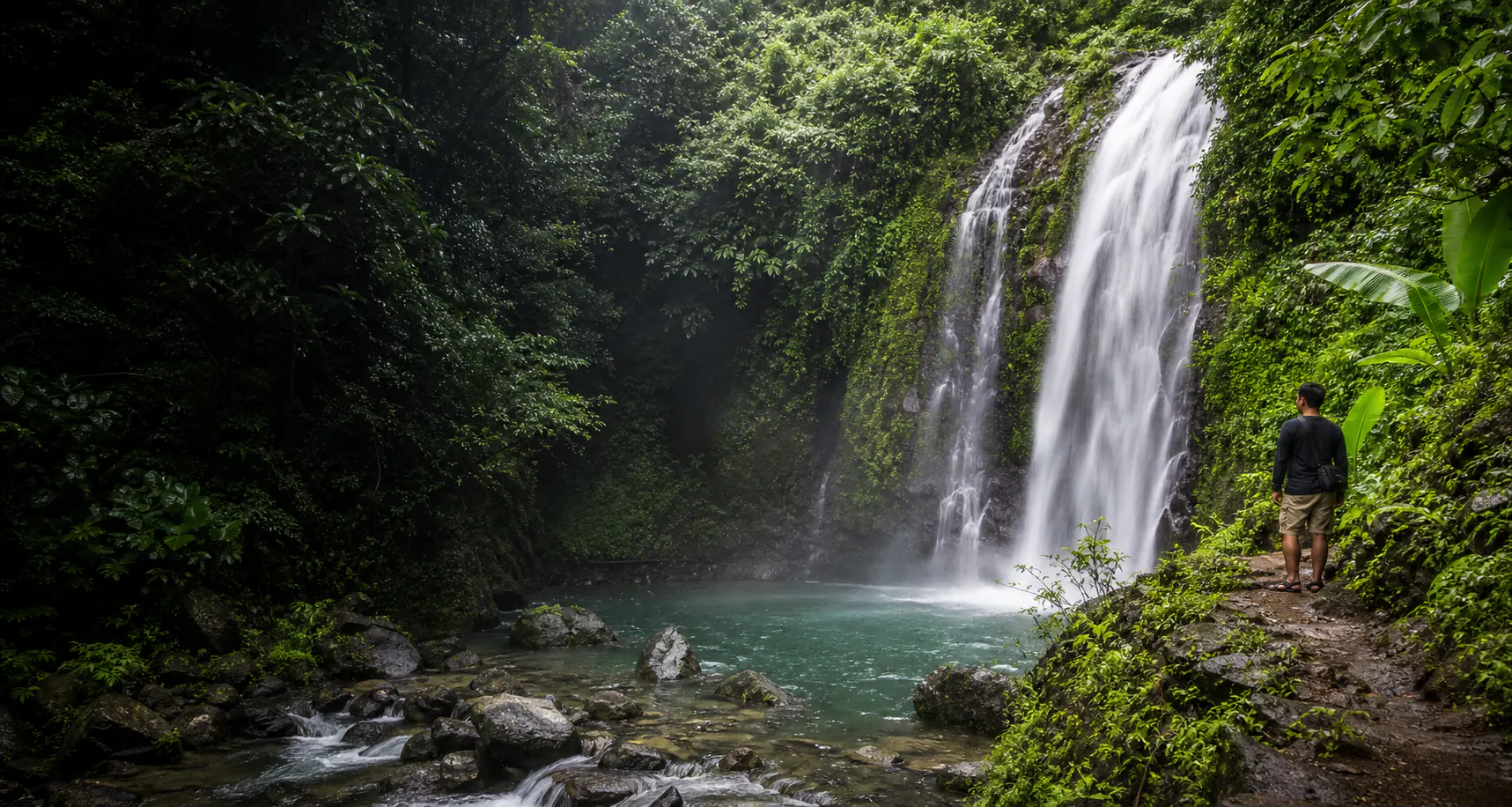 Tropical rainforest waterfall surrounded by deep green foliage