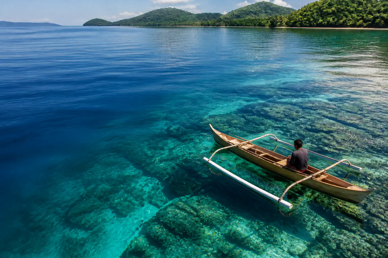 Traditional fishing boat above clear coral shallows